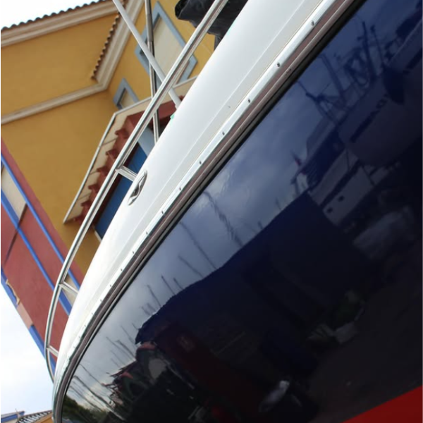 Casco azul brillante con borda blanca tras el vinilado de un yate en Alicante